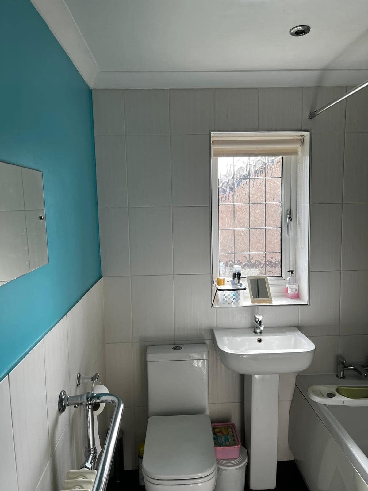 Original bathroom showing toilet, sink and tired finishes