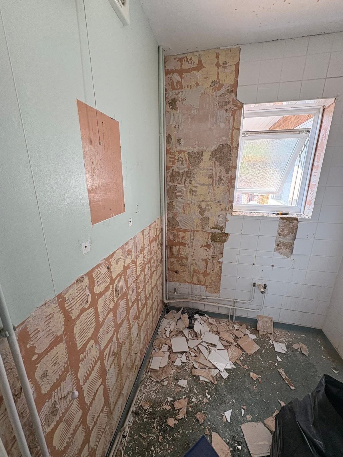 Bathroom mid strip-out, stripped back to bare walls and floor